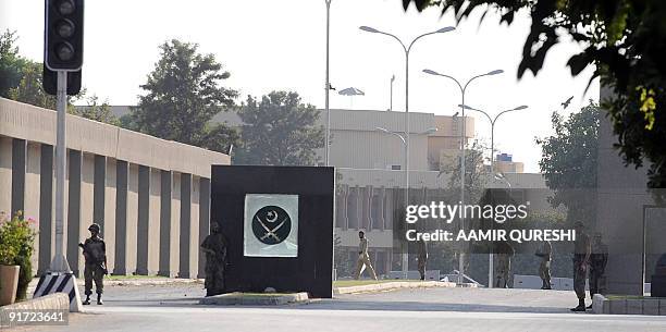 Pakistani army officials collect evidence at the main entrance of Pakistan�s army headquarters after a heavily armed militant attack in Rawalpindi on...