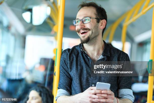 hipster mit smartphone in einem bus - mann bus smartphone stock-fotos und bilder