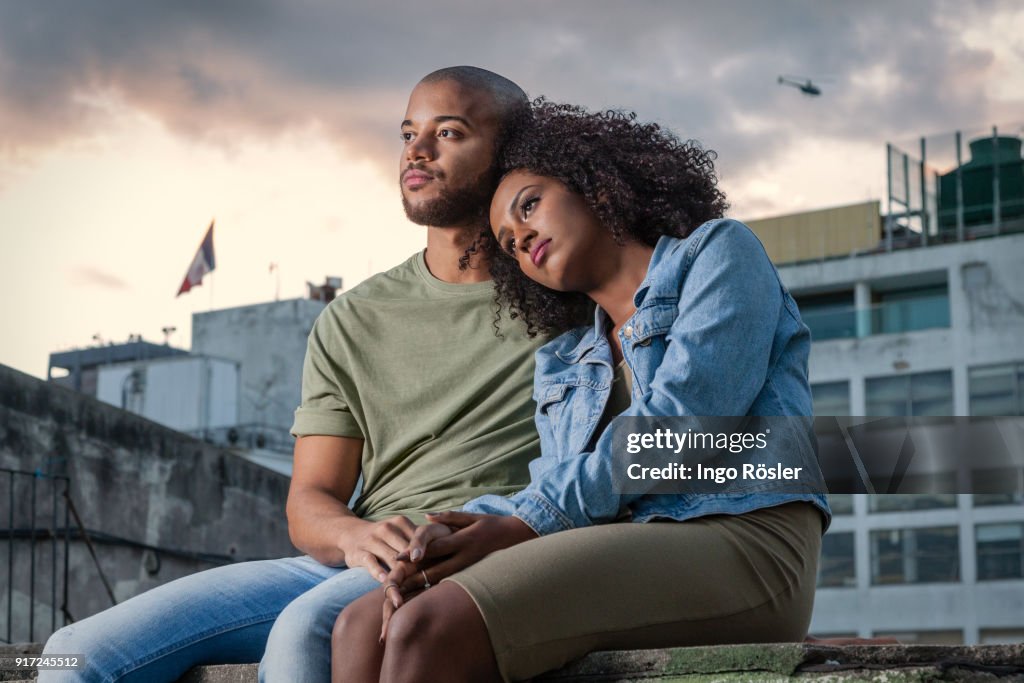 Young couple sitting on rooftop