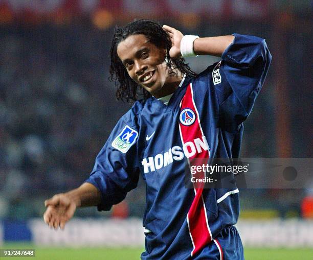 Le milieu de terrain brésilien du PSG Ronaldinho, auteur des premiers buts pour son équipe, salue les supporteurs parisiens, le 26 octobre 2002 au...