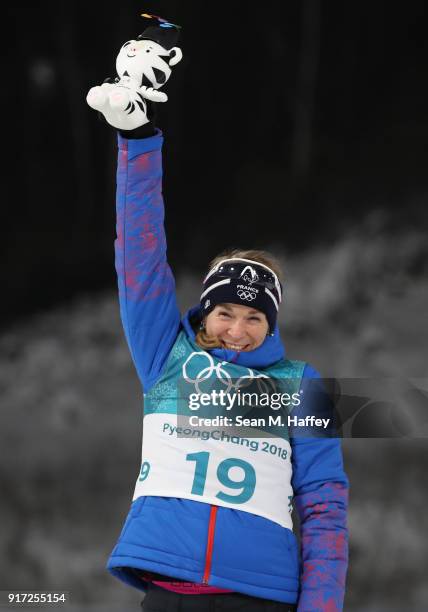 Bronze medalist Anais Bescond of France celebrates during the victory ceremony after the Women's Biathlon 10km Pursuit on day three of the...