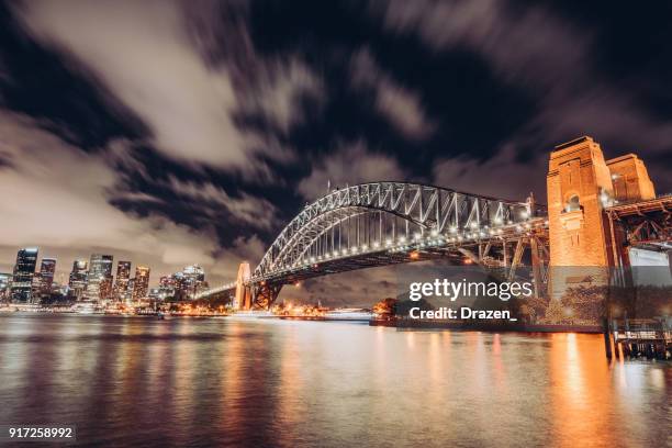 dramatic sky over the sydney harbour at night - sydney harbour boats stock pictures, royalty-free photos & images