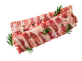Isolated image of raw pork ribs with seasoning  rosemary, pepper on white background, top view
