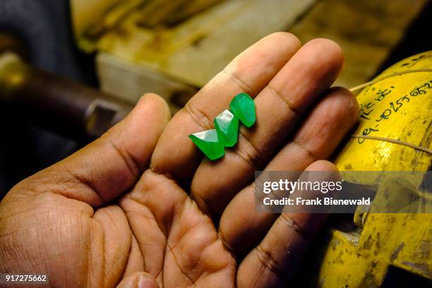 Close up of a worker checking precious jade stones after polishing in the jade market.