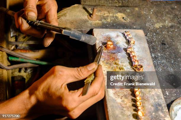 Close up of a worker soldering jewellery in the jade market.