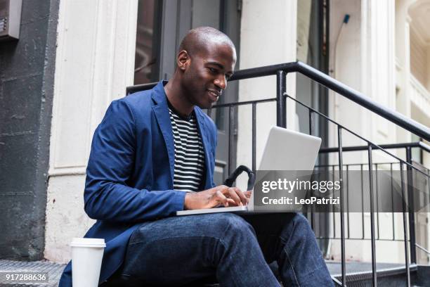 jonge creatieve zakenman in new york - african creative with laptop working outside stockfoto's en -beelden