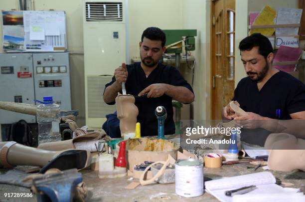 Men work on prosthetic limbs at a rehabilitation center in Erbil, Iraq on February 11, 2018. The rehabilitation center serves since 1996 within the...