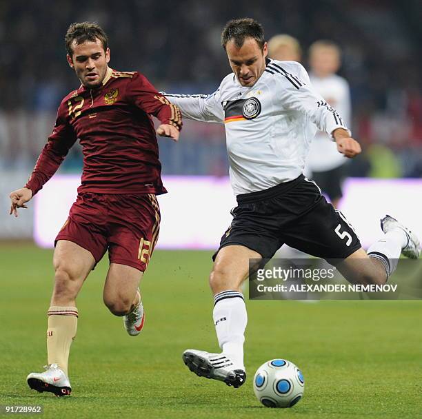 Russian Vladimir Gabulov fights for the ball with German Heiko Westermann in Moscow on October 10 during their European Group Four match World Cup...