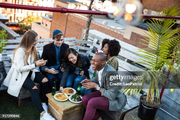 friends party on a rooftop in new york manhattan - aperitif stock pictures, royalty-free photos & images