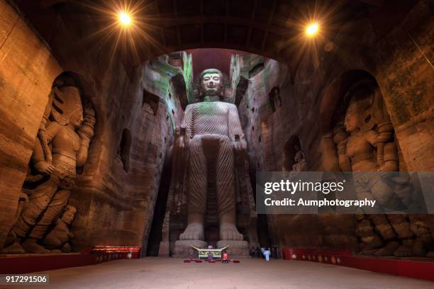 the tourist standing and stunning in front of the big buddha, admires the greatest splendid of the giant leshan buddha. - buda gigante de leshan - fotografias e filmes do acervo