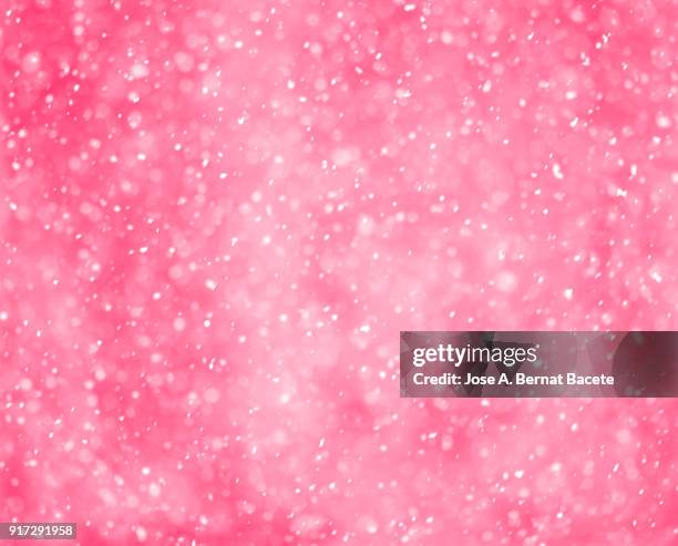 background of snowflakes of snow that fall down from the sky on a light pink bottom. spain - pink background stock pictures, royalty-free photos & images