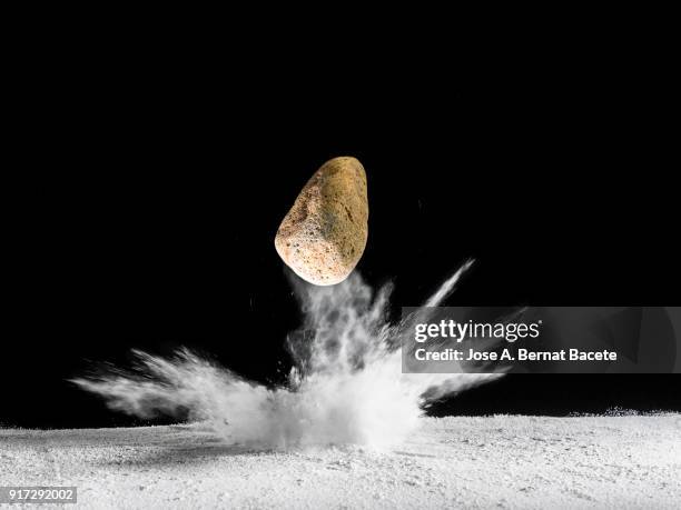 impact of meteorite,  rock or stone of fire on the soil, producing an explosion and a crater of powder on a black background. spain - bomb drops stock pictures, royalty-free photos & images