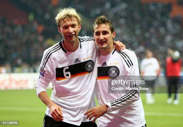 Miroslav Klose of Germany celebrates with team mate Simon Rolfes after winning the FIFA 2010 World Cup Group 4 Qualifier match between Russia and...