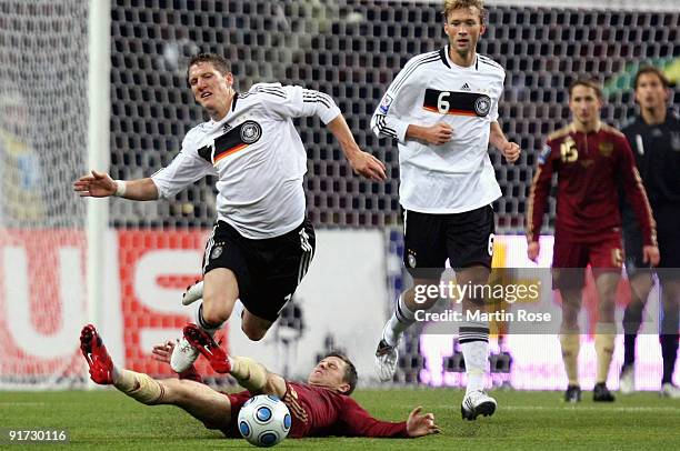 Igor Semshov of Russia and Bastian Schweinsteiger of Germany battle for the ball during the FIFA 2010 World Cup Group 4 Qualifier match between...