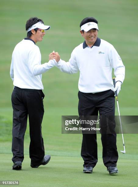 Ryo Ishikawa and Y.E. Yang of the International Team celebrate a birdie on the first hole during the Day Three Morning Foursome Matches of The...
