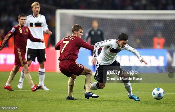 Igor Denisov of Russia and Mesut Oezil of Germany battle for the ball during the FIFA 2010 World Cup Group 4 Qualifier match between Russia and...