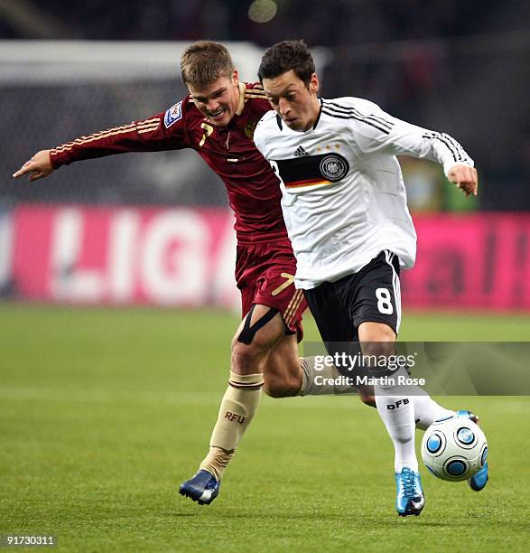 Igor Denisov of Russia and Mesut Oezil of Germany battle for the ball during the FIFA 2010 World Cup Group 4 Qualifier match between Russia and...
