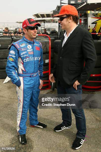 Actor John C. Reilly talks with NASCAR driver Greg Biffle during practice for the NASCAR Sprint Cup Series Pepsi 500 at Auto Club Speedway on October...
