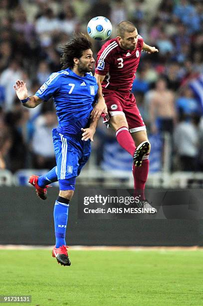 Greece's Georgios Samaras fights for the ball with Latvia's Oskars Klava during their 2010 World Cup qualification football game at the Athens...