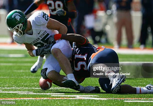 Evan Frierson of the Illinois Fighting Illini tackles Blair White of the Michigan State Spartans causing an apparent fumble that was ruled down on...