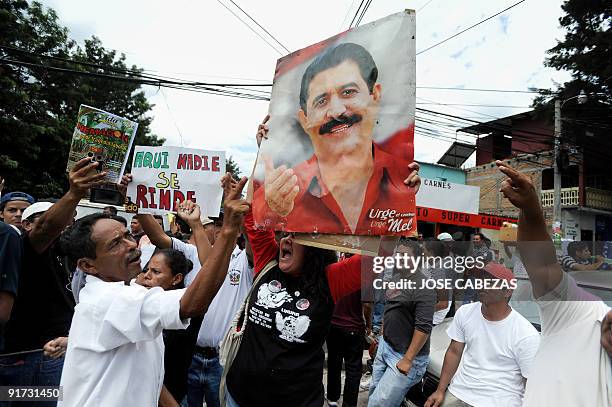 Supporters of ousted Honduran president Manuel Zelaya shout slogans during a protest against the military coup d'etat in El Hato de En medio...