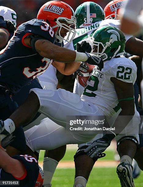 Larry Caper of the Michigan State Spartans is hit by Ian Thomas of the Illinois Fighting Illini on October 10, 2009 at Memorial Stadium at the...