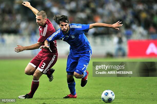 Greece's Georgios Samaras fights for the ball with Latvia's Oskars Klava during their 2010 World Cup qualification football game at the Athens...