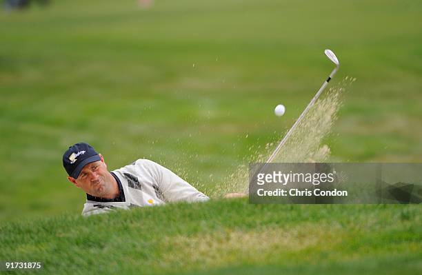 Stewart Cink of the U.S. Team hits from a bunker at the 17th green during the third round morning foursome matches for The Presidents Cup at Harding...