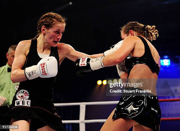 Ina Menzer of Germany exchanges punches with Esther Schouten of the Netherlands during the WIBF, WBC and WBO world championship fight during the...