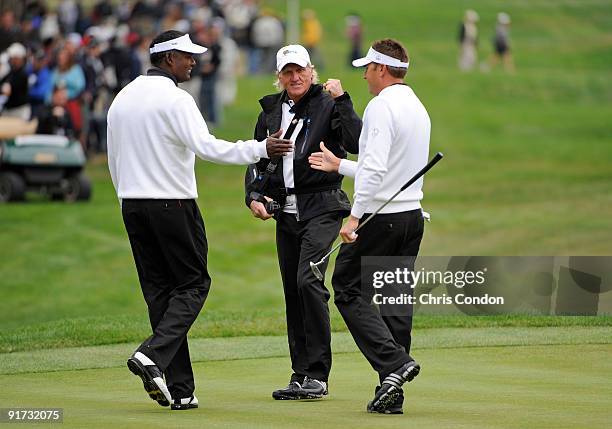 Vijay Singh and Robert Allenby of the International Team celebrate a big par save with Captain Greg Norman during the third round morning foursome...