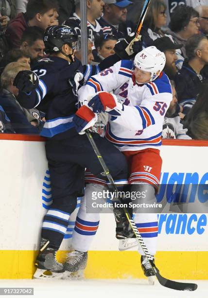 Winnipeg Jets Right Wing Jack Roslovic is checked by New York Rangers Defenceman Nick Holden during a NHL game between the Winnipeg Jets and New York...