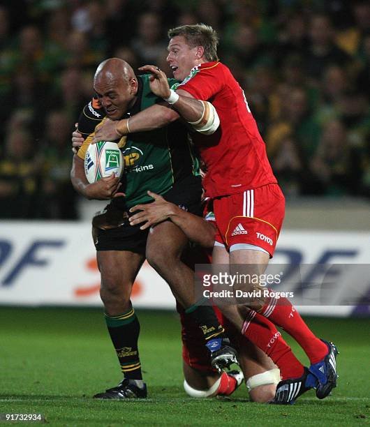 Soane Tonga'uiha of Northampton is tackled by Jean de Villiers during the Heineken Cup match between Northampton Saints and Munster at Franklin's...