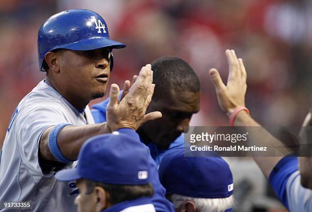 Ronnie Belliard of the Los Angeles Dodgers high fives teammates after scoring on a RBI single hit by Rafael Furcal in the fourth inning of Game Three...