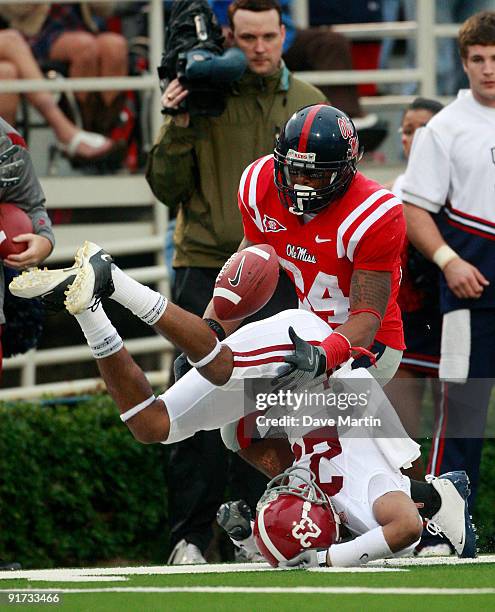 Running back Brandon Bolden of the Mississippi Rebels battles for a pass with Robby Green of the Alabama Crimson Tide during their college football...