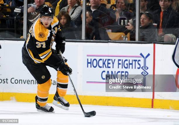 Patrice Bergeron of the Boston Bruins skates with the puck against the New York Islanders at the TD Garden that displays a 'Hockey Fights Cancer'...