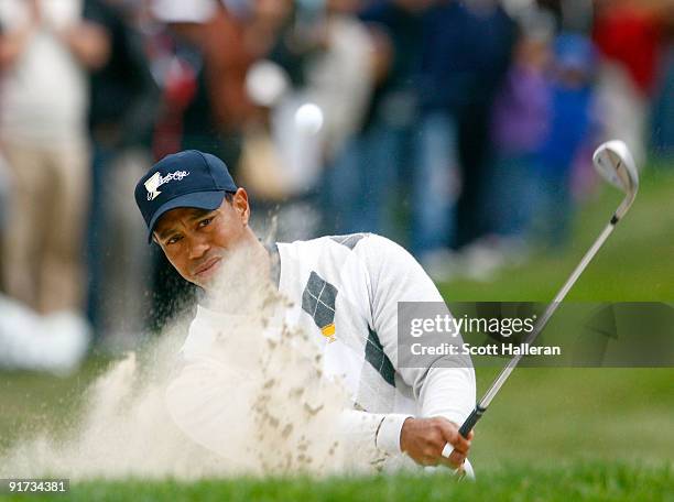 Tiger Woods of the USA Team hits out of the bunker on the 11th hole during the Day Three Afternoon Fourball Matches of The Presidents Cup at Harding...