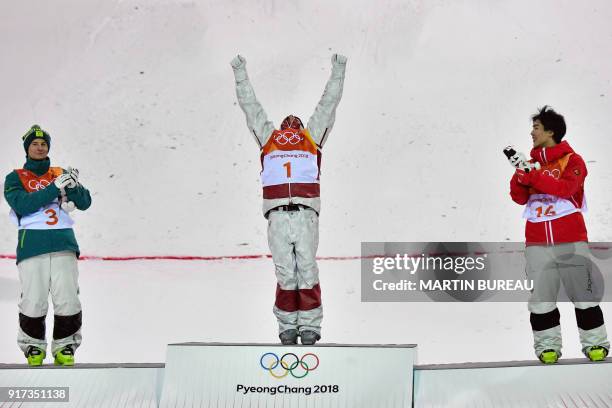 Australia's Matt Graham, Canada's Mikael Kingsbury and Japan's Daichi Hara celebrate on the podium during the victory ceremony after the men's moguls...