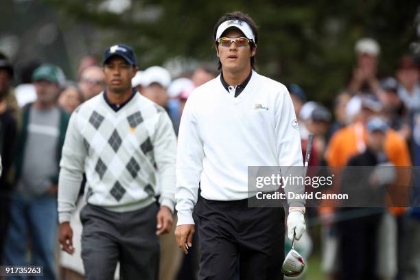 Ryo Ishikawa of Japan and the International Team walks from the 6th tee followed by Tiger Woods of the USA Team during the Day Three Afternoon...