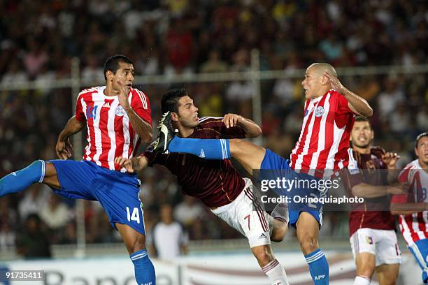 Nicolas Fedor of Venezuela vies for the ball with Paulo Cesar da Silva and Dario Veron of Paraguay during their match as part of the 2010 FIFA World...