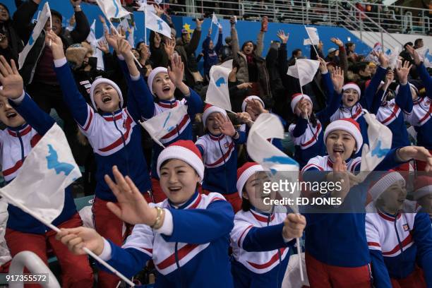 North Korean cheerleaders hold the flags of the unified Korean team during the women's preliminary round ice hockey match between Korea and Sweden,...