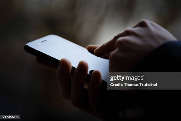 Berlin, Germany Symbolic photo on the subject of data security on the smartphone. Hands are typing on a smartphone on February 12, 2018 in Berlin,...