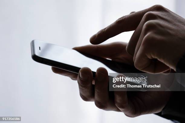 Berlin, Germany Symbolic photo on the subject of data security on the smartphone. Hands are typing on a smartphone on February 12, 2018 in Berlin,...