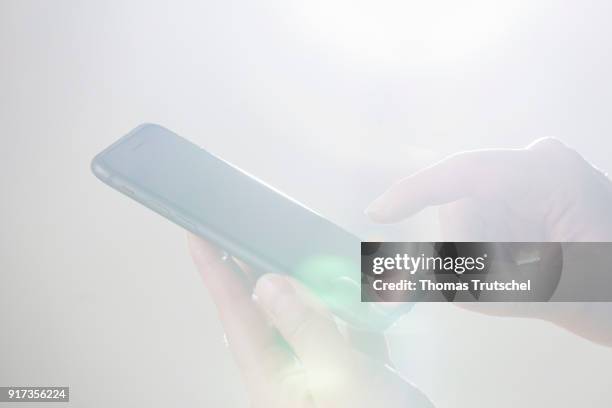 Berlin, Germany Symbolic photo on the subject of data security on the smartphone. Hands are typing on a smartphone on February 12, 2018 in Berlin,...