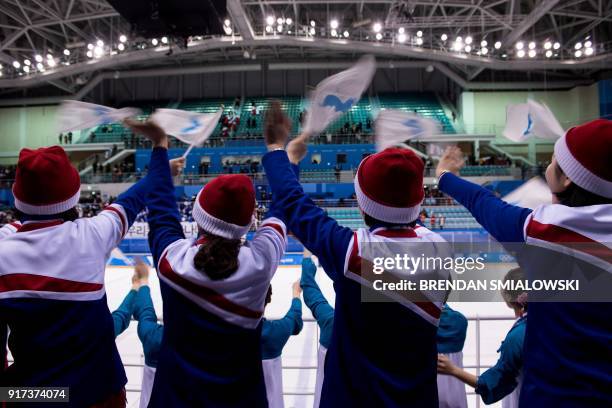 North Korean cheerleaders wave the Unified Korea flags after the women's preliminary round ice hockey match between Sweden and Unified Korea during...