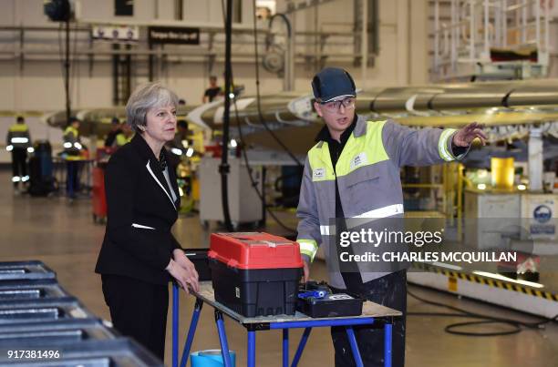 British Prime Minister Theresa May speaks to Josh Barnes , an operations worker, during a visit to the Belfast Bombardier factory in Belfast on...