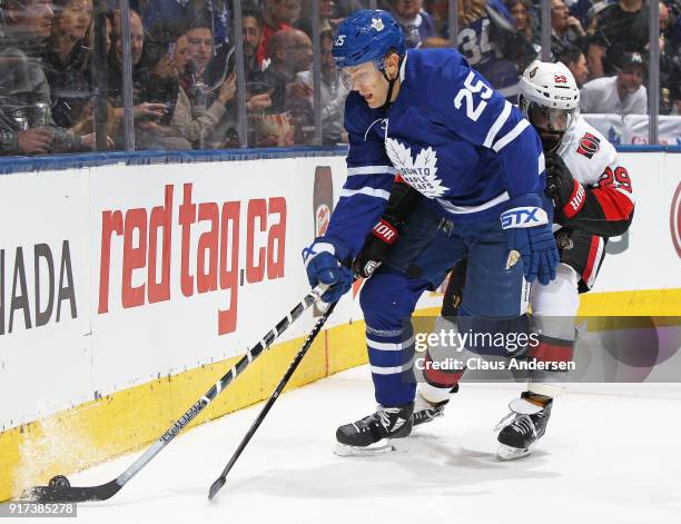 Johnny Oduya of the Ottawa Senators tries to contain James van Riemsdyk of the Toronto Maple Leafs during an NHL game at the Air Canada Centre on...