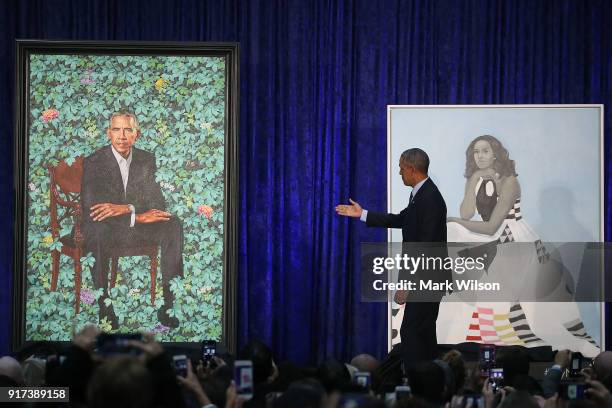 Former U.S. President Barack Obama stands with his and first lady Michelle Obama's newly unveiled portrait during a ceremony at the Smithsonian's...
