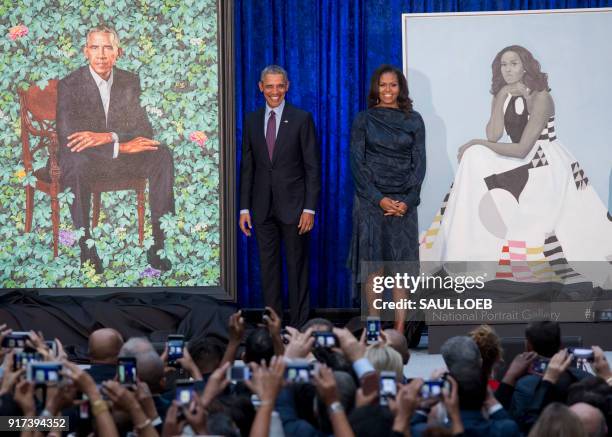 Former US President Barack Obama and First Lady Michelle Obama stand beside their portraits after their unveiling at the Smithsonian's National...