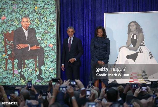 Former U.S. President Barack Obama and former first lady Michelle Obama stand next to their newly unveiled portraits during a ceremony at the...