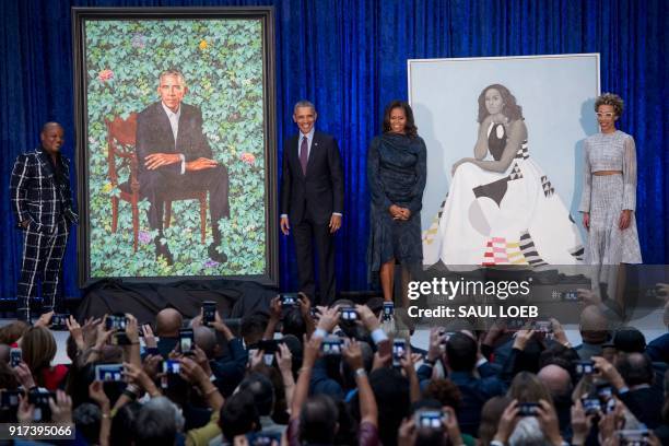 Former US President Barack Obama and First Lady Michelle Obama stand before their portraits and respective artists, Kehinde Wiley and Amy Sherald ,...